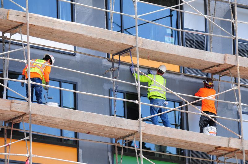 Contruction workers renovating the facade of a building