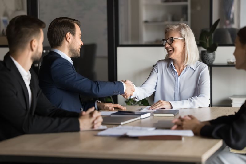 Woman and man shaking hands at business meeting